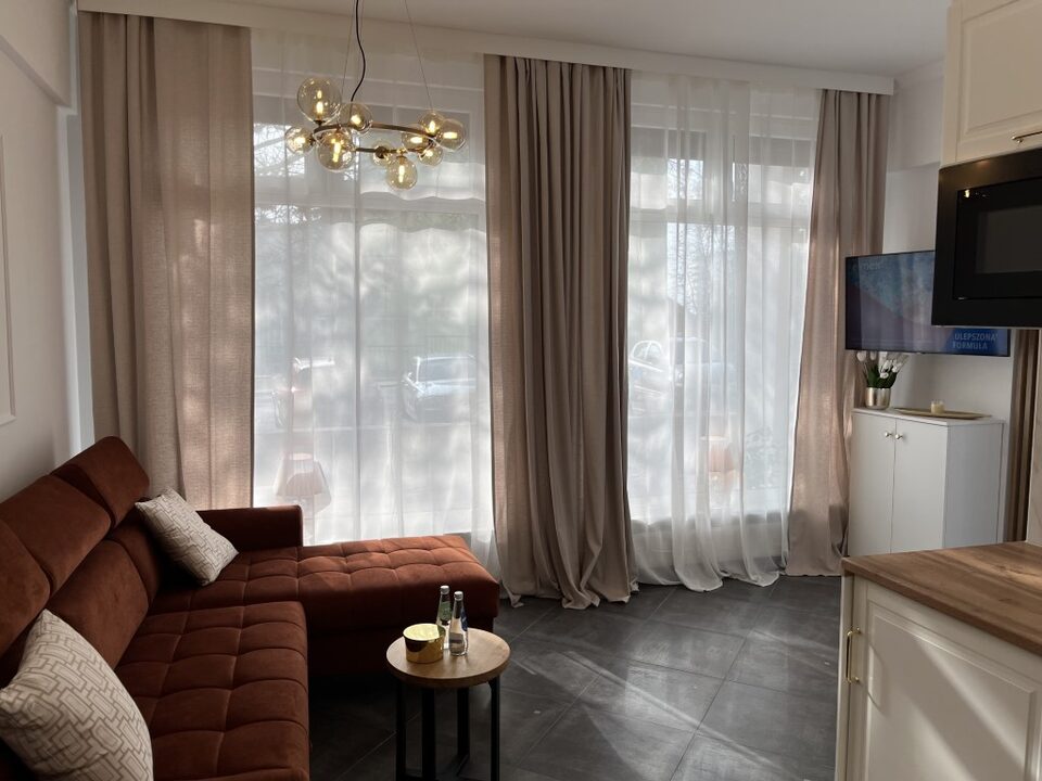 Stue med sofa og store vinduer – Lejlighed Amore, Międzyzdroje
