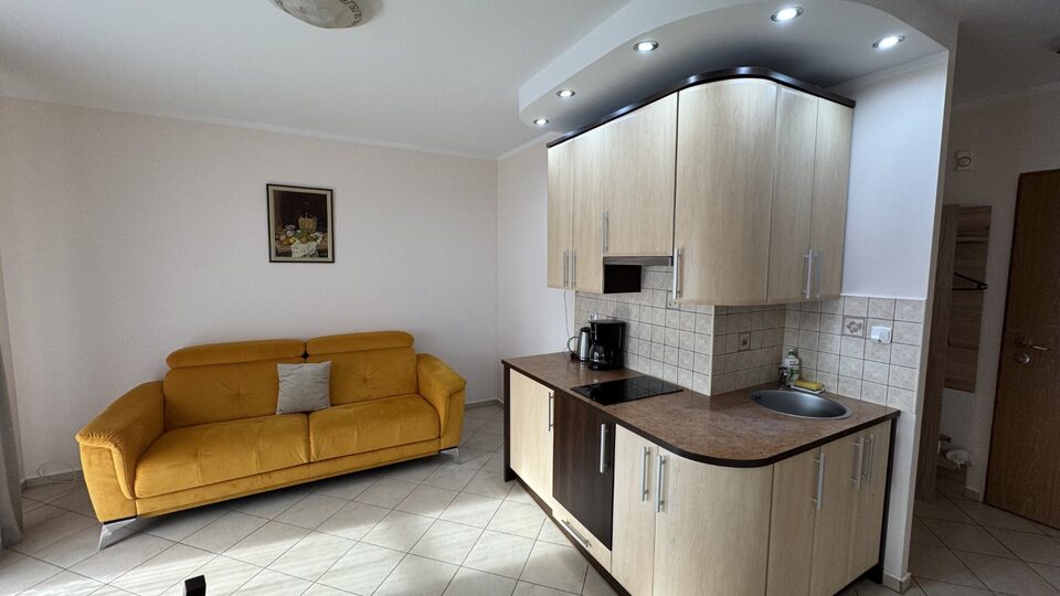 Wohnzimmer mit Sofa und Küchenzeile – Apartment Fala 111, Międzyzdroje