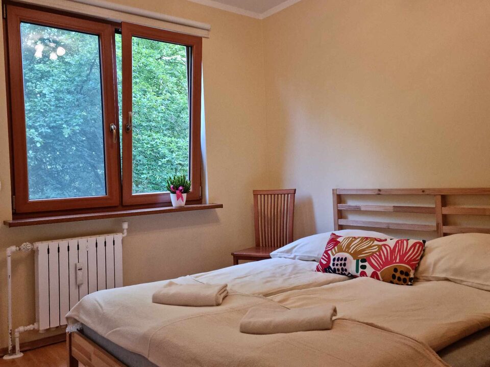Lit près de la fenêtre donnant sur la verdure – Appartement Turystyczna 2A, Międzyzdroje