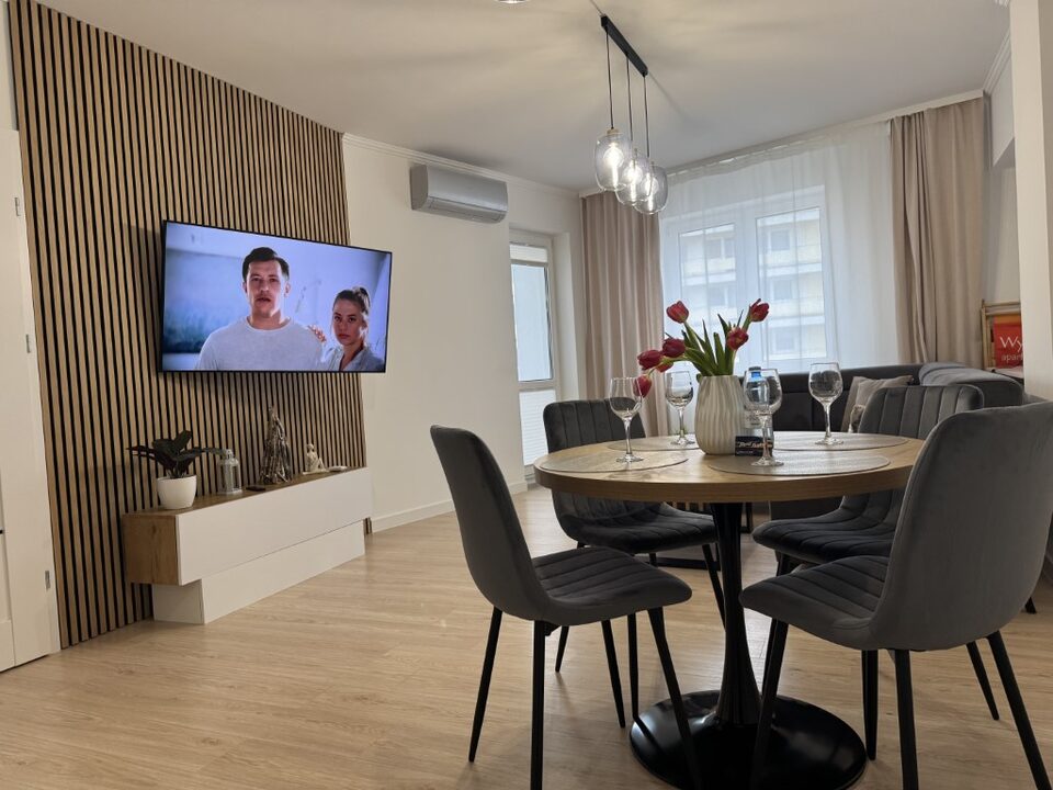 Stue med spiseplads og tv på lamelvæg – Statek 416 med sauna og havudsigt, Międzyzdroje