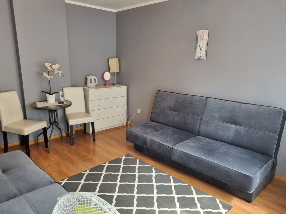Chambre avec canapé, petite table et commode – Chambres d'hôtes, Międzyzdroje