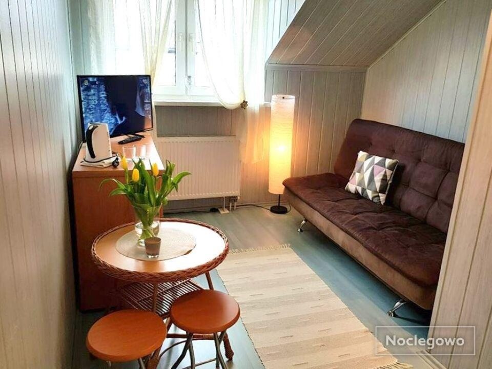 Chambre mansardée avec petite table et canapé – Chambres d'hôtes, Międzyzdroje
